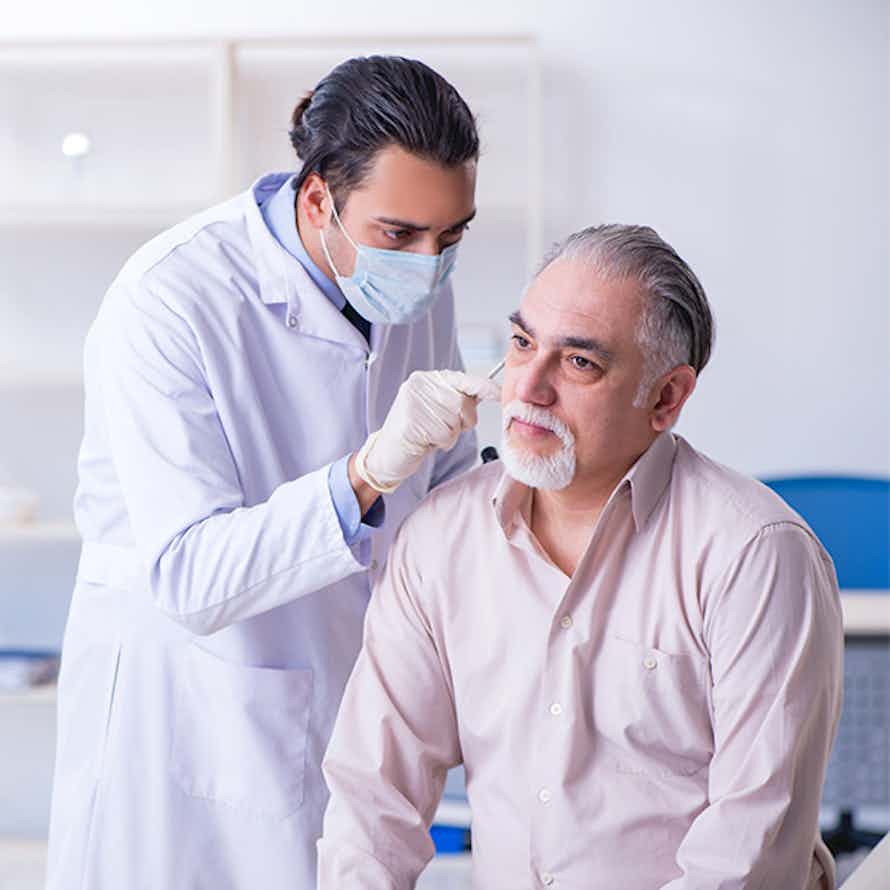 Doctor examining a male patient during a cancer screening.